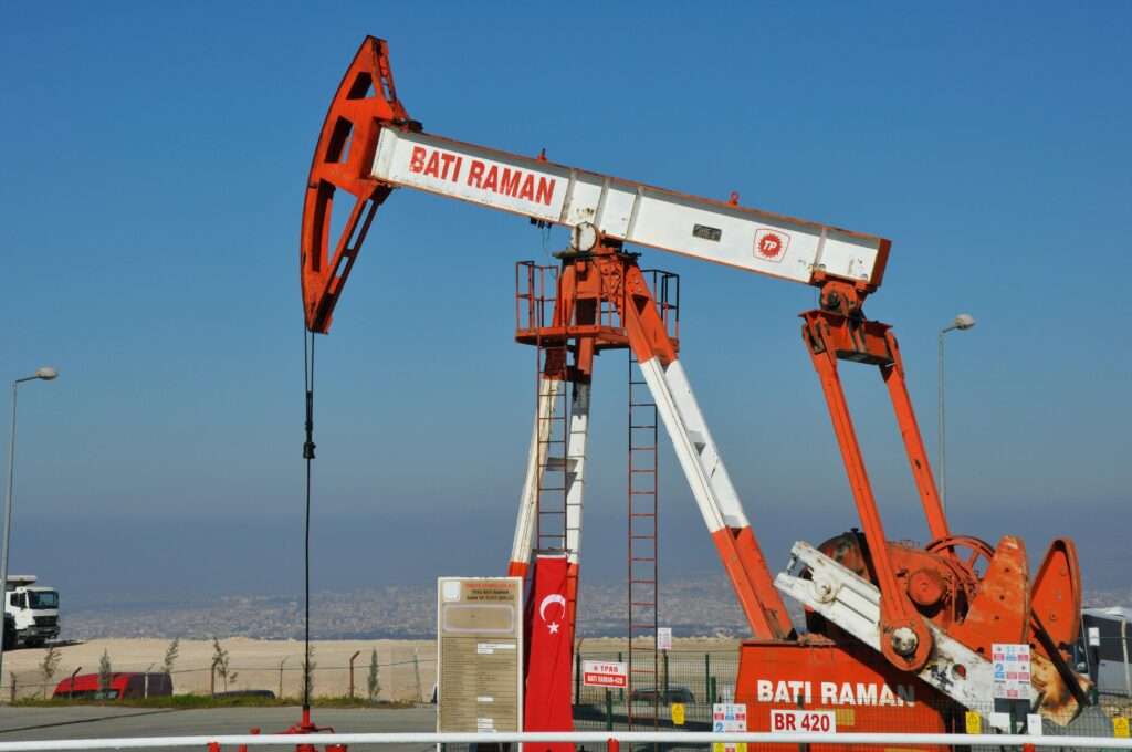 Bati Raman oil pump jack in Batman, Turkey. Industrial landscape with city view.