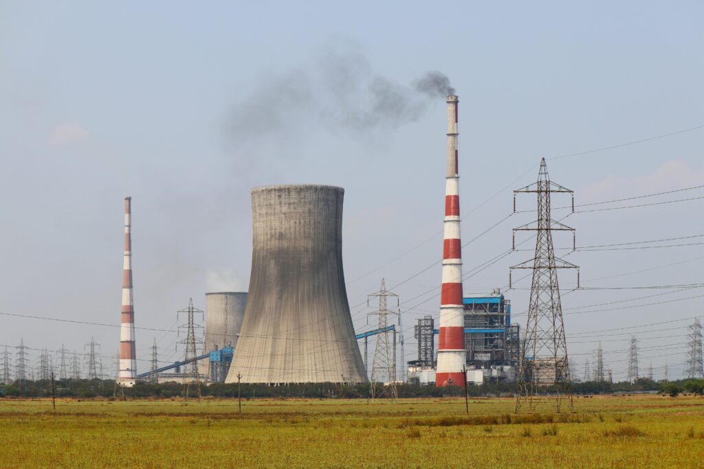Smokestacks and a cooling tower emit smoke at a power plant in Vijayawada, India.